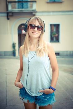 beautiful blonde woman listening to music in the city