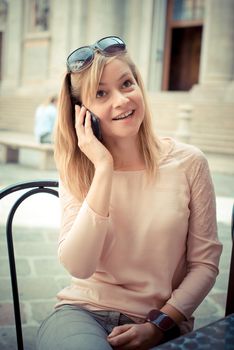 beautiful blonde woman on the phone at the bar in the city