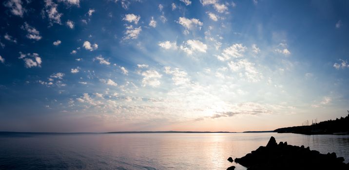 Tranquil sunrise panorama of lake and clouds