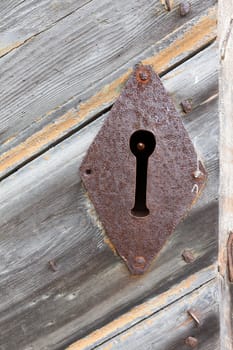 Closeup of a rustic empty lock on a wooden door