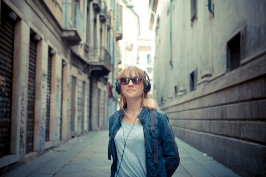 beautiful blonde woman listening to music in the city