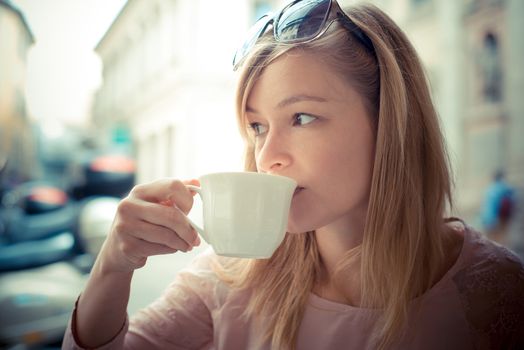 beautiful blonde woman having breakfast at the bar in the city