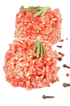 Two Fresh Raw Beef Burgers with Rosemary and Pepper Corns isolated on white background