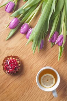 Fresh violet tulips on the wooden table, vertical