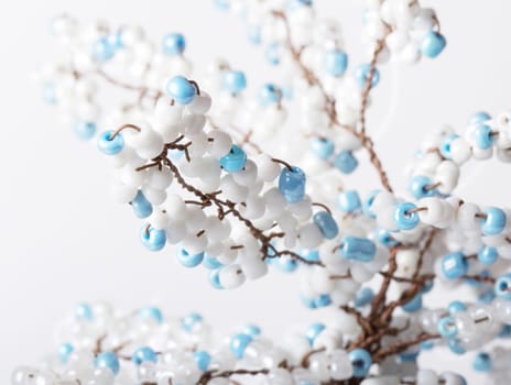 Hand made tree branch decorated with beads isolated. Close up