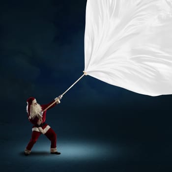 Santa Claus pulls a banner of cloth with a rope, place for text