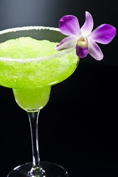 Green margarita cocktail in front of disco lights