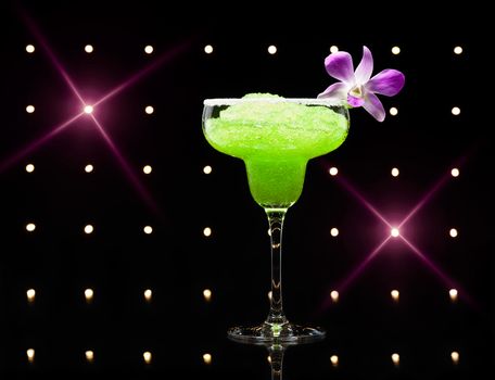 Green margarita cocktail in front of disco lights