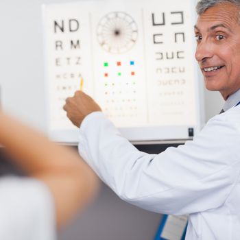 Doctor smiling while doing an eye test on a patient in a hospital examination room