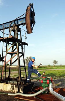 oil worker with hammer on oilfield