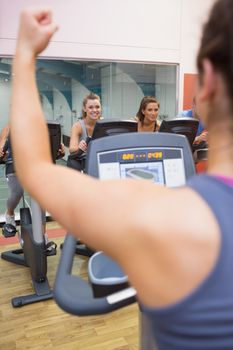 Motivational female instructor teaches spinning class at gym