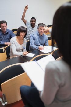 Smiling man asking question in lecture in college