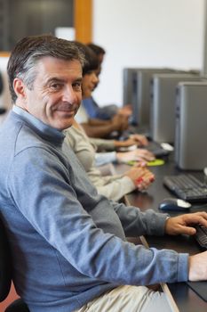 Man sitting at the computer and smiling at the university