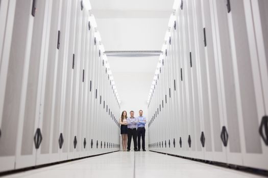 Three techncians standing at end of server hallway in data center