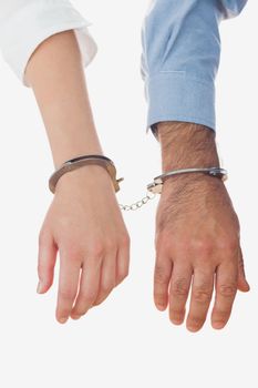 Hands of business people in handcuffs over white background