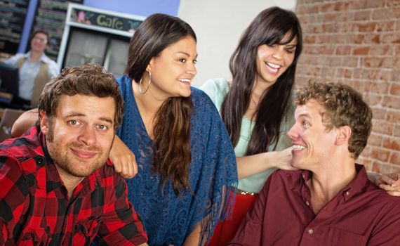 Happy group of cheerful young friends in bistro
