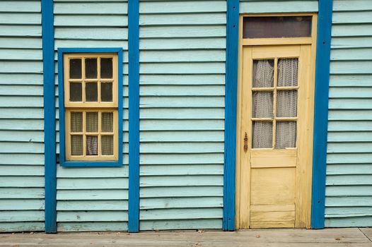 Blue wooden wall with window and door