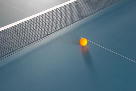Orange table tennis ball on blue table