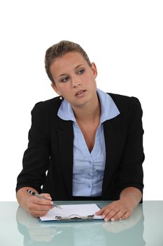 Blond woman sat at desk with blank clip-board