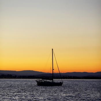 Silhouette of a yacht in the sea at sunset