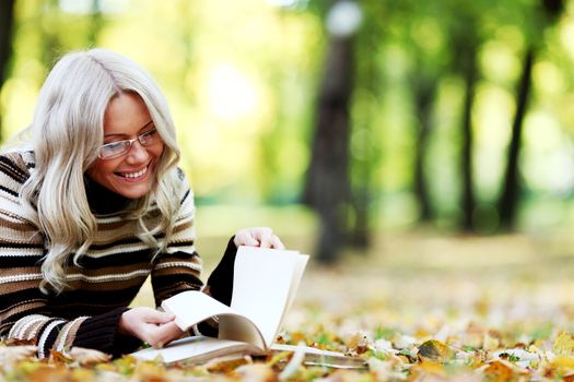 woman read the book in autumn park