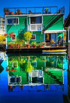 Green Houseboat Floating Home VFisherman's Wharf Reflection Inner Harbor, Victoria Vancouver British Columbia Canada Pacific Northwest.  Close to the center of Victoria, this area has floating homes, boats, piers, and restaurants.