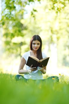 Woman reading book in park outdoors