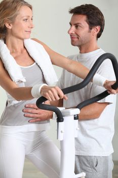 Man showing woman how to use exercise machine