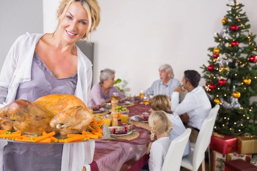 Proud mother showing roast turkey at christmas