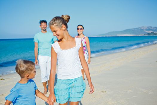 Family of four having fun on tropical beach