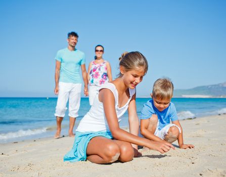 Family of four having fun on tropical beach