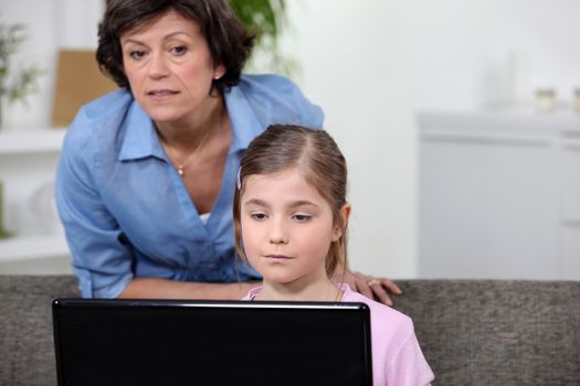 Woman and girl looking at a laptop computer