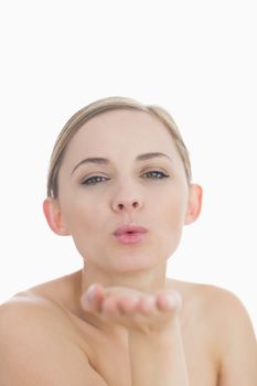 Closeup of cute young woman blowing a kiss over white background