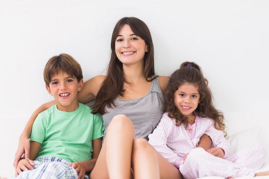 Smiling mother in bed with children