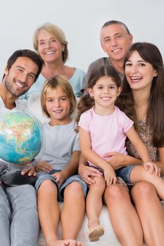 Happy family sitting on the couch with a globe