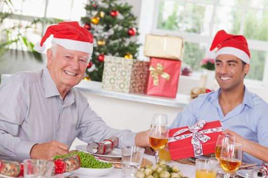 Family swapping christmas presents at christmas dinner
