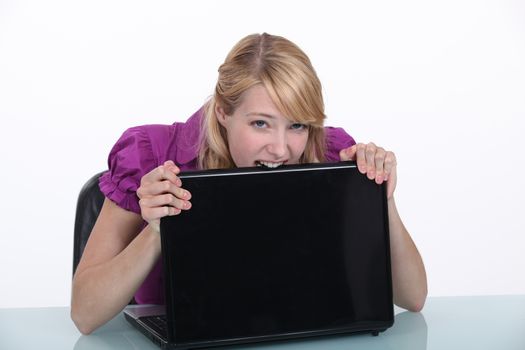 Woman eating her laptop in frustration