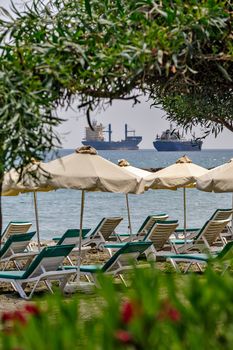 Resort beach and freight ships on horizon