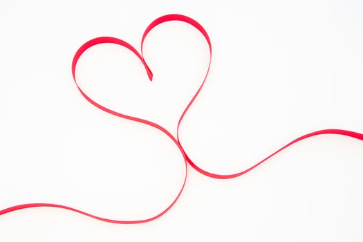 Heart shaped pink ribbon on white background