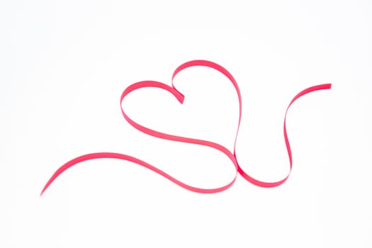 Decorative ribbon shaped into a heart on white background