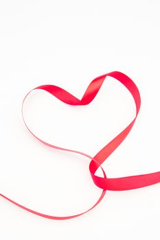 Pretty pink heart made out of ribbon on white background