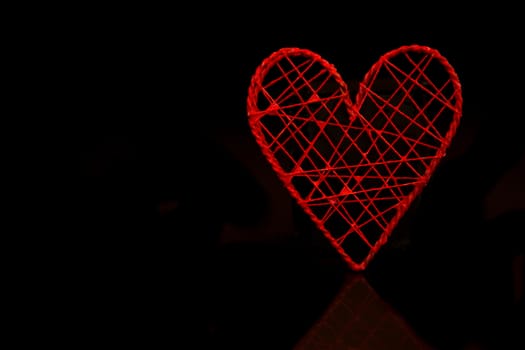 Red heart shaped ornamental box on black background