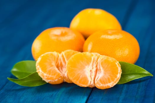 Mandarin halves with leaves on blue wood (Selective Focus, Focus on the front of the mandarin half) 