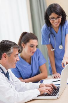 Nurses and doctor looking at laptop in a meeting