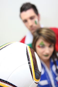 Couple of Italian soccer fans holding ball