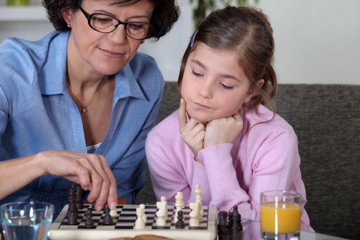 Girl and her grandmother playing chess