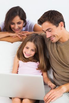Family using the laptop sittitng on a sofa