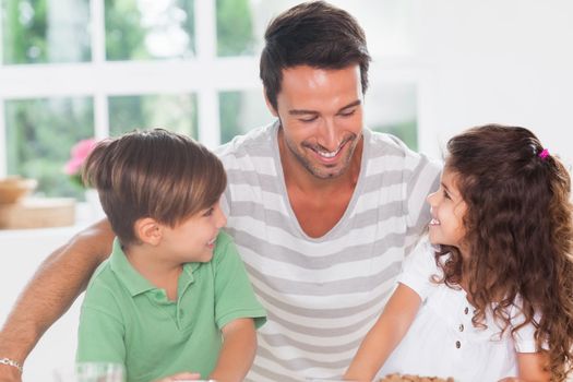 Two children and their father in kitchen