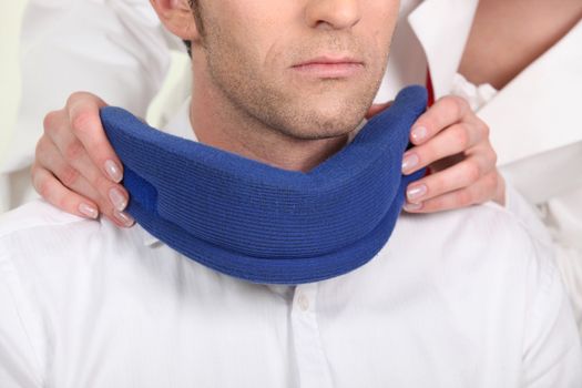 Nurse attaching a neck brace for a male patient