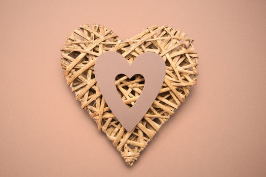 Wicker heart ornament with paper cut out on purple background